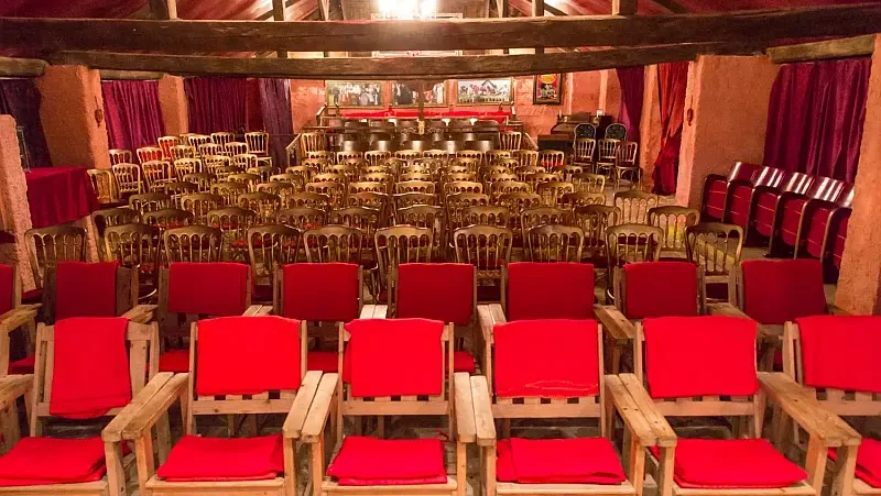 Historischer Theaterstadl mit Holzverkleidung, Holzsesseln mit roten Polstern, Holzbalken an der Decke, leer