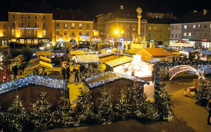 Beleuchteter Hauptplatz Wiener Neustadt bei Nacht, mit beleuchteten Adventständen mit Weihnachtsdekorationen