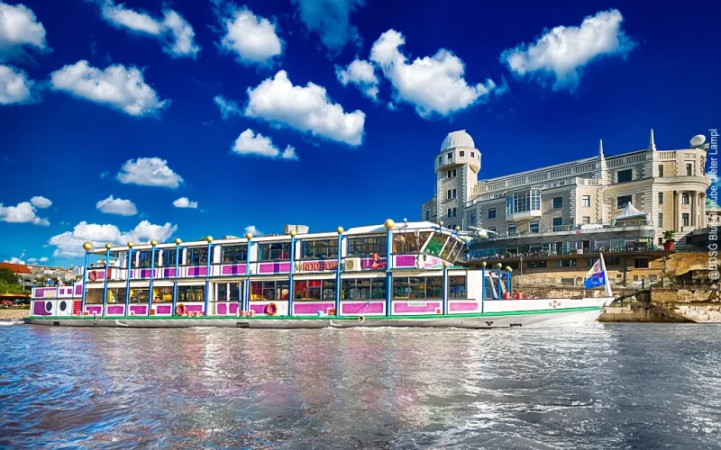 Donauschiff MS Vindobona mit 2 Decks auf dem Donaukanal vor der Urania-Sternwarte, blauer Himmel mit weißen Wolken im Hintergrund
